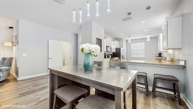dining space with recessed lighting, baseboards, and light wood-style floors