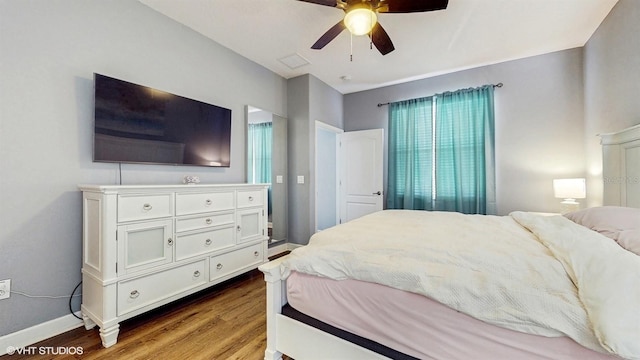 bedroom featuring visible vents, baseboards, ceiling fan, and wood finished floors