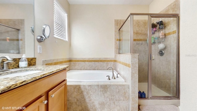 bathroom with vanity, a garden tub, and a stall shower