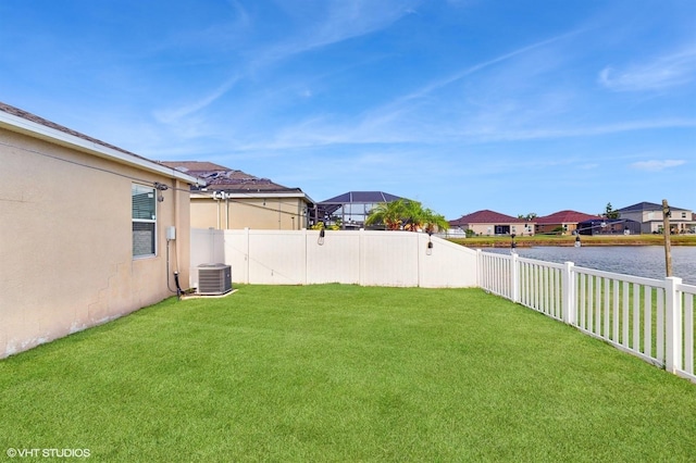 view of yard with central air condition unit, a water view, a residential view, and a fenced backyard