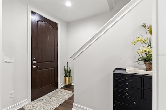 foyer featuring baseboards and wood finished floors