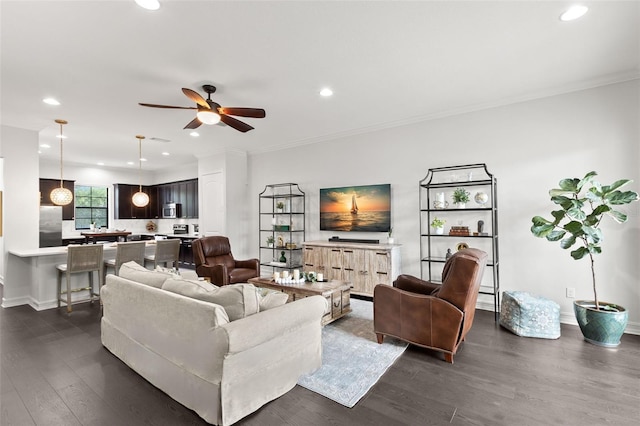living area with recessed lighting, a ceiling fan, dark wood-type flooring, and crown molding