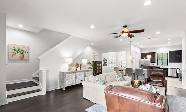living room with ornamental molding, wood finished floors, stairway, recessed lighting, and a ceiling fan