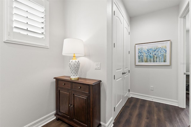 corridor with baseboards and dark wood-style flooring