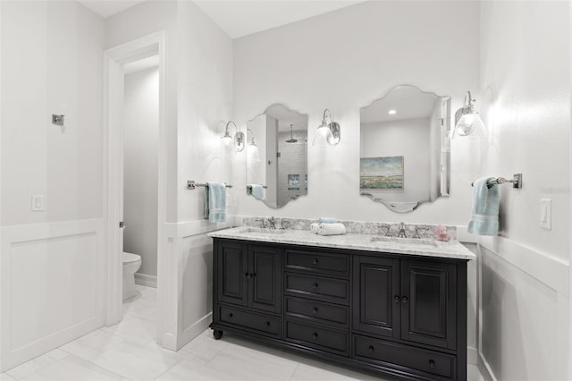 full bathroom with a sink, toilet, double vanity, and marble finish floor