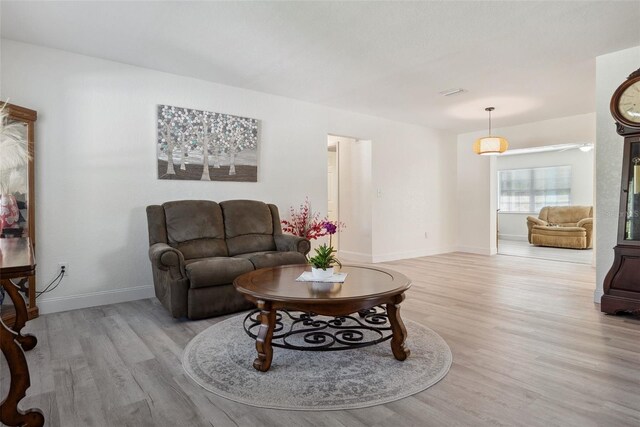 living area with baseboards and light wood finished floors
