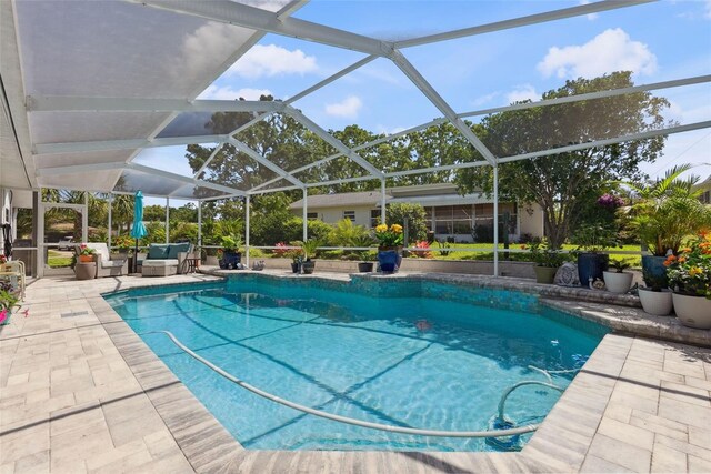 outdoor pool featuring glass enclosure and a patio area