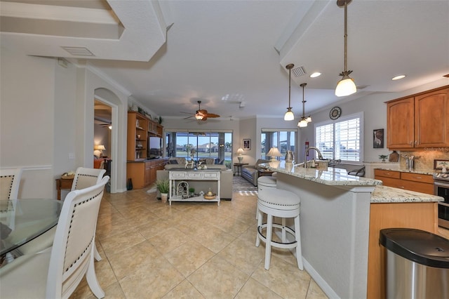 kitchen with visible vents, open floor plan, ceiling fan, and a wealth of natural light