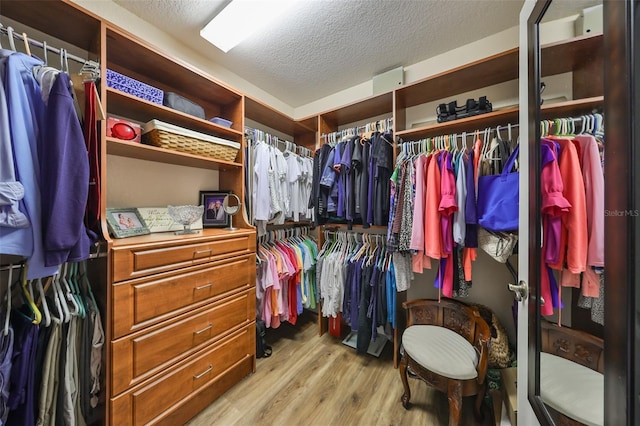 walk in closet with light wood-style flooring