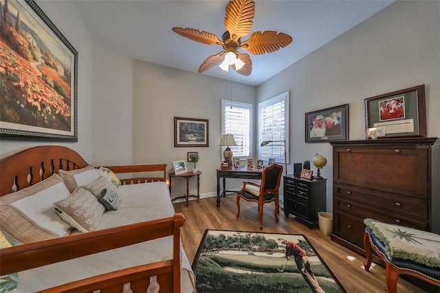 bedroom featuring baseboards, a ceiling fan, and wood finished floors