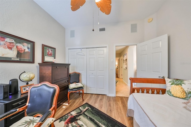 bedroom featuring visible vents, baseboards, wood finished floors, and a closet