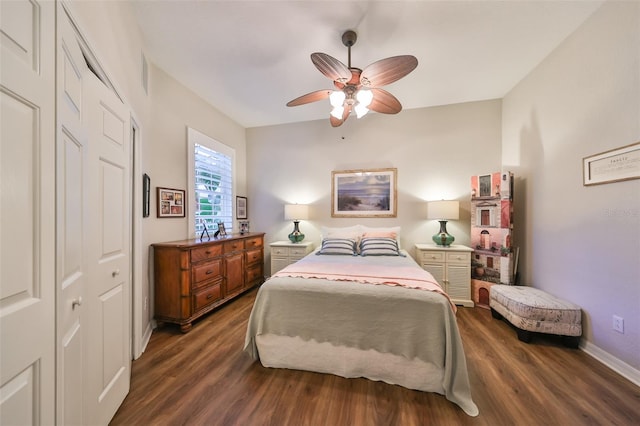 bedroom with a closet, dark wood finished floors, ceiling fan, and baseboards