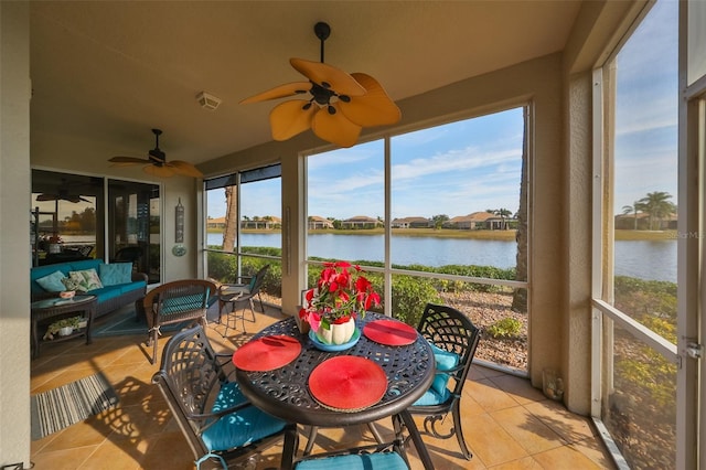 sunroom / solarium with tile patterned flooring, a ceiling fan, a water view, and outdoor lounge area