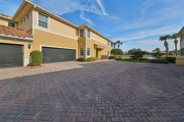 view of front facade featuring decorative driveway and stucco siding