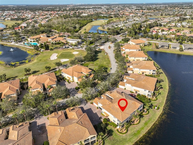 drone / aerial view with a water view, view of golf course, and a residential view