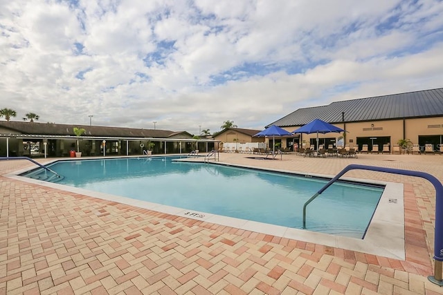 pool featuring fence and a patio area