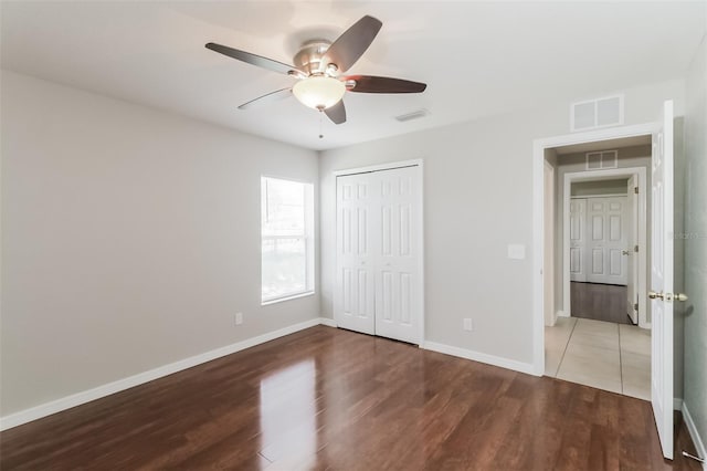 2203 Malaga Ave, Spring Hill, FL 34609 - unfurnished bedroom with wood finished floors, baseboards, a closet, and ceiling fan