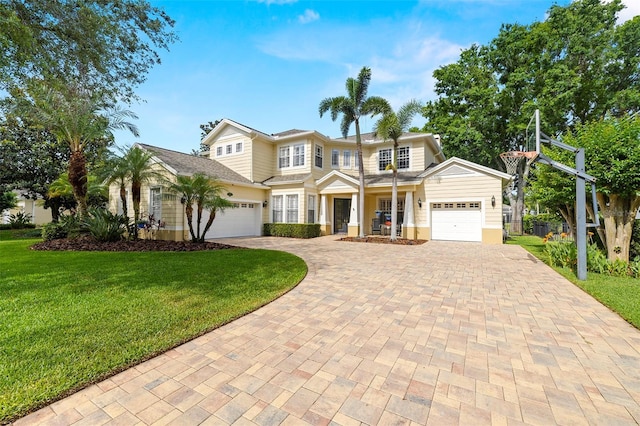 traditional-style house with an attached garage, decorative driveway, and a front yard