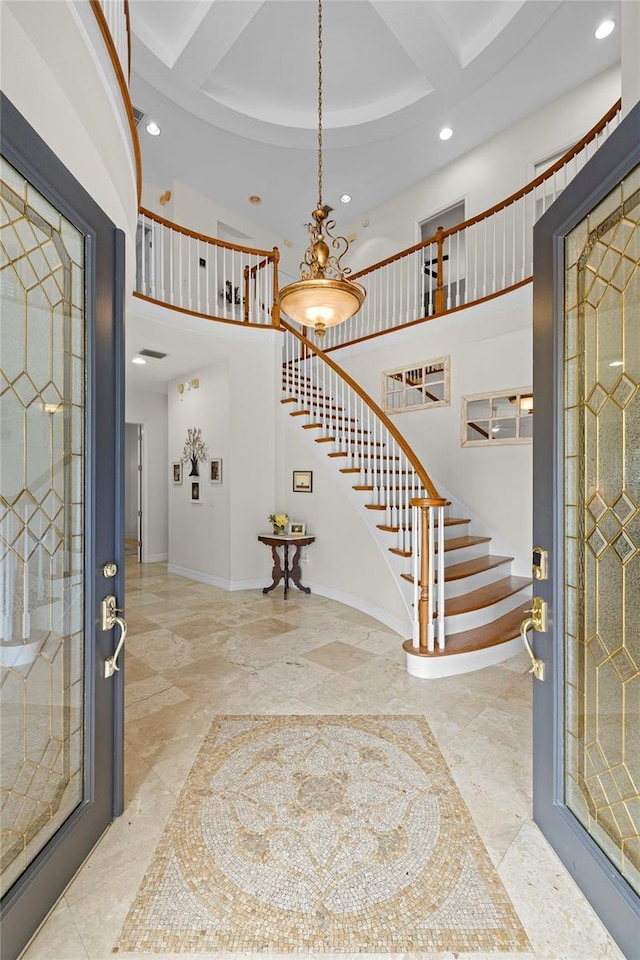 foyer entrance featuring stairs, recessed lighting, baseboards, and a high ceiling