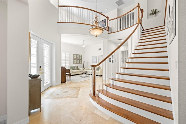 entryway featuring a high ceiling, a ceiling fan, baseboards, visible vents, and stairway