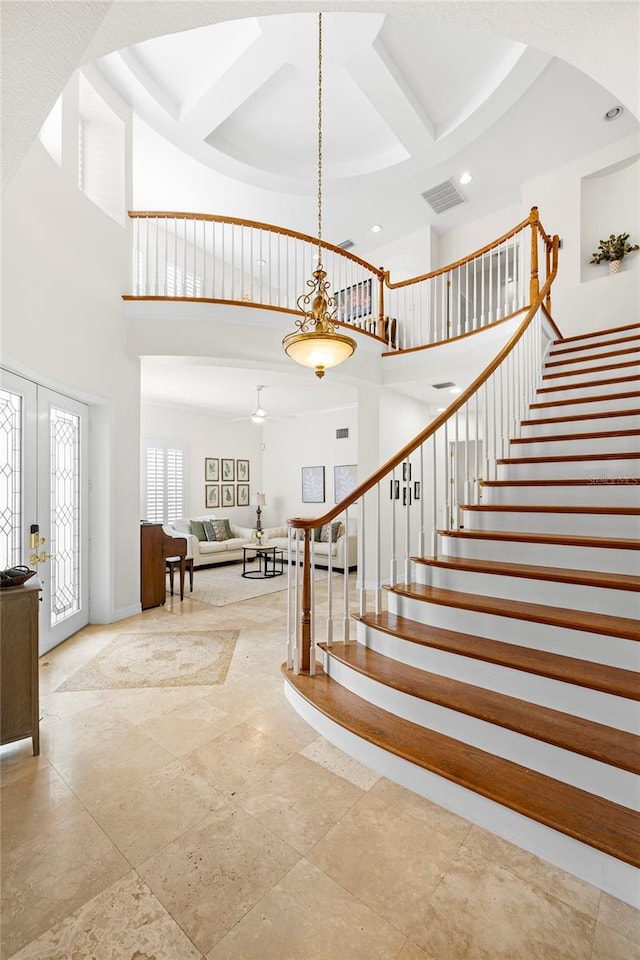 staircase with french doors, recessed lighting, baseboards, a towering ceiling, and visible vents