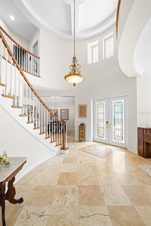 foyer with french doors, baseboards, stone tile flooring, a high ceiling, and stairs