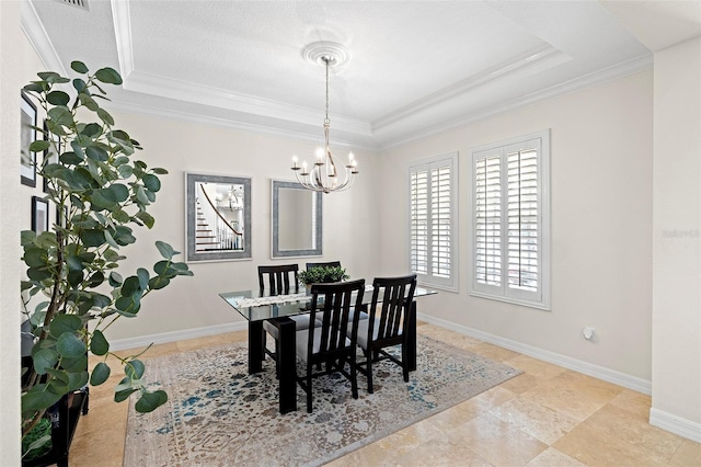 dining area with crown molding, baseboards, a tray ceiling, and a chandelier