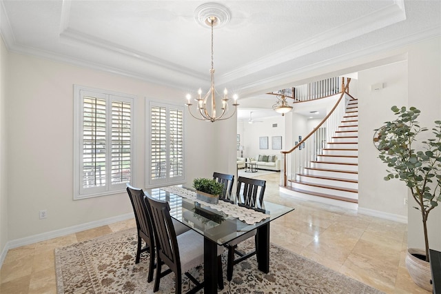 dining room with crown molding, a raised ceiling, and a chandelier