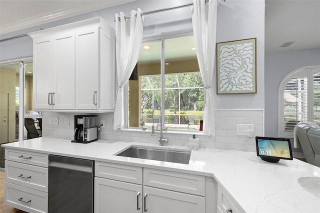 kitchen with backsplash, white cabinetry, a sink, and dishwasher
