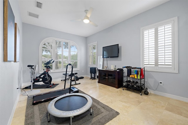 exercise area with visible vents, a ceiling fan, and baseboards