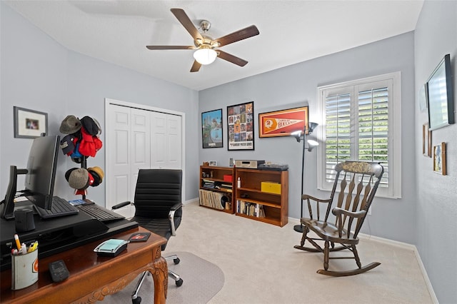 carpeted home office featuring baseboards and a ceiling fan