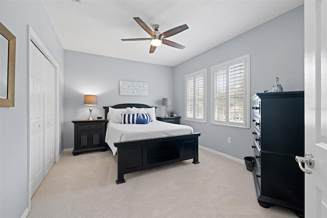 bedroom with a ceiling fan, baseboards, light carpet, and a closet