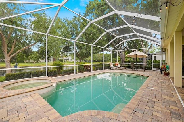 view of swimming pool with a pool with connected hot tub, a lanai, and a patio area