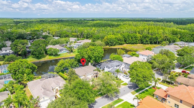 drone / aerial view featuring a water view, a residential view, and a forest view