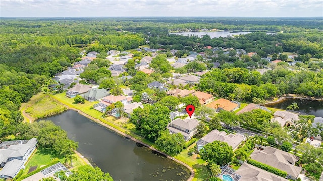 birds eye view of property with a water view, a view of trees, and a residential view