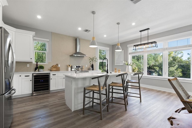 116 W Stanley St, Tampa, FL 33604 - kitchen with beverage cooler, stainless steel appliances, wall chimney range hood, a sink, and light countertops