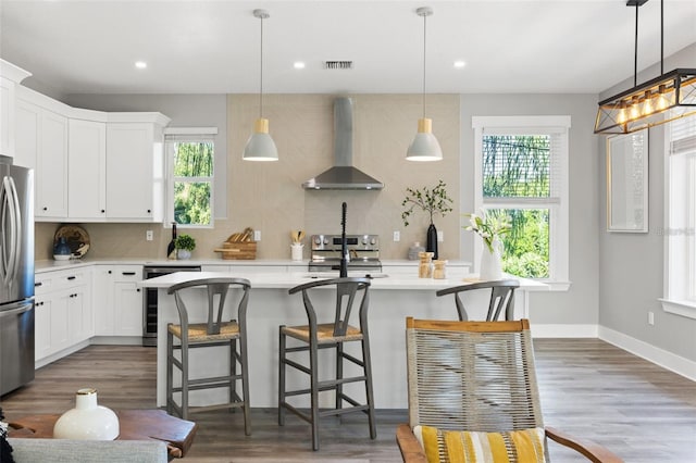 116 W Stanley St, Tampa, FL 33604 - kitchen featuring wall chimney exhaust hood, plenty of natural light, light countertops, appliances with stainless steel finishes, and recessed lighting