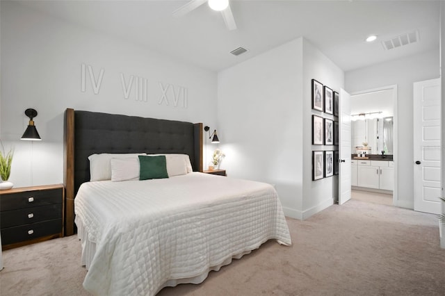 bedroom featuring baseboards, visible vents, light carpet, and ensuite bath