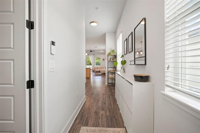 hall featuring baseboards, recessed lighting, and dark wood-type flooring
