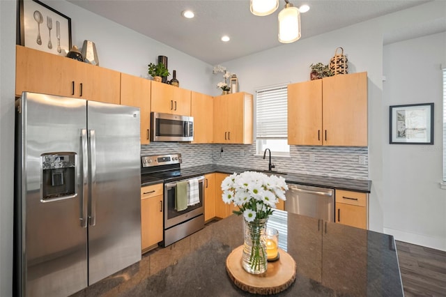 kitchen featuring dark wood-style flooring, light brown cabinetry, dark countertops, tasteful backsplash, and stainless steel appliances