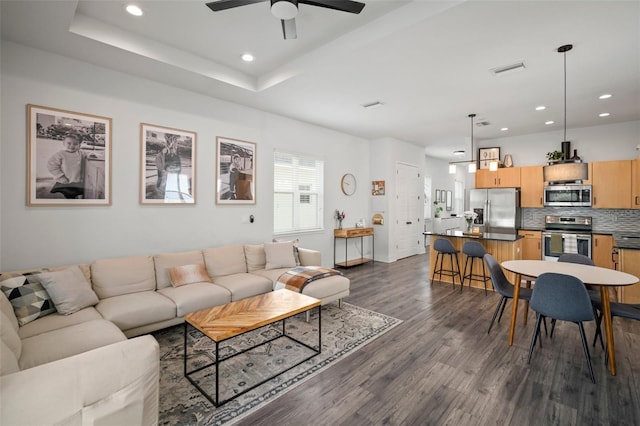 living room with ceiling fan, recessed lighting, baseboards, dark wood-type flooring, and visible vents