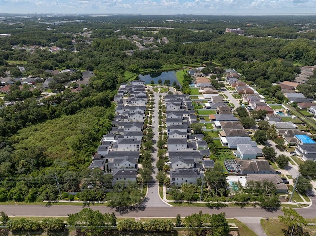 drone / aerial view featuring a water view, a residential view, and a forest view