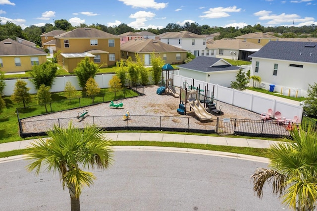 communal playground featuring fence and a residential view