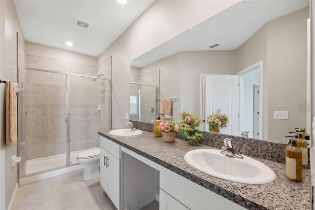 bathroom featuring tile patterned flooring, a sink, a stall shower, and toilet