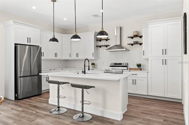 121 E Warren Ave Unit 1, Tampa, FL 33602 - kitchen with stainless steel appliances, wall chimney range hood, light countertops, a sink, and white cabinetry