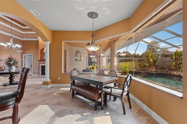 dining room with a fireplace, arched walkways, baseboards, ornate columns, and visible vents
