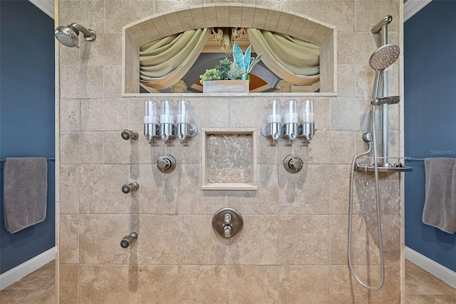 bathroom with baseboards and tiled shower