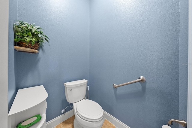 bathroom with baseboards, tile patterned flooring, and toilet
