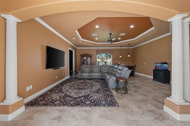 cinema room with baseboards, ornate columns, ceiling fan, and a tray ceiling