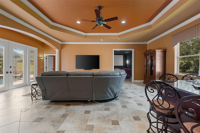 living room featuring crown molding, ceiling fan, french doors, and a raised ceiling